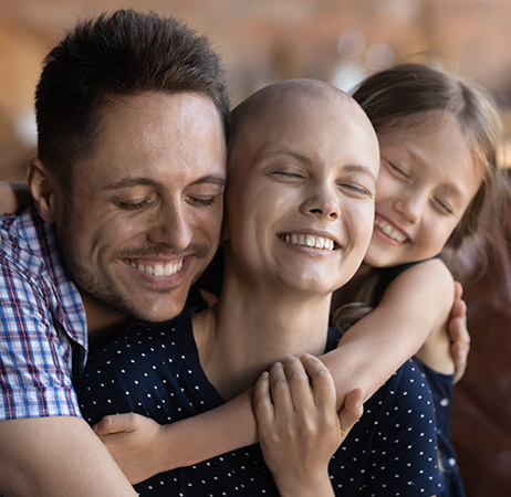 Photo of family smiling; woman is cancer patient